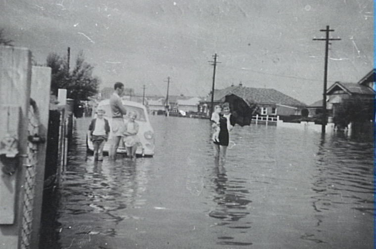 Family in flood waters in the vicinity of Storey Street