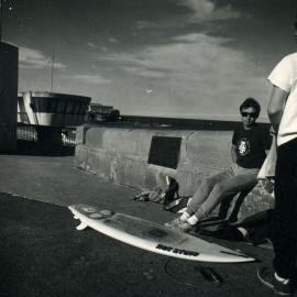 Surfers leaning against the Coogee Promenade