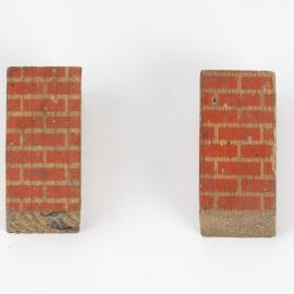 Set of two rectangular shaped toy building blocks, one side painted with orange bricks