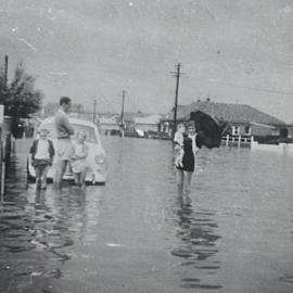 Family in flood waters in the vicinity of Storey Street