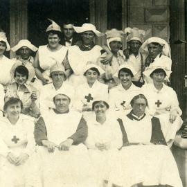 Men and Women dressed as Nurses sitting on the front steps of a hospital